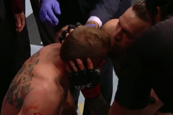 Conor McGregor mencium Donald Cerrone setelah pertandingan berakhir pada UFC 246 di T-Mobile Arena, Las Vegas, Minggu (19/1/2020). 