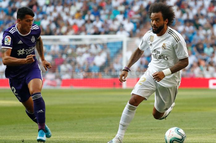 Bek kiri Real Madrid, Marcelo (kanan), mendapatkan penjagaan ketat dari pemain Real Valladolid, Pedro Porro, ketika keduanya berlaga dalam laga La Liga Spanyol pada Ahad (25/8/2019) di Stadion Santiago Bernabeu, Madrid.