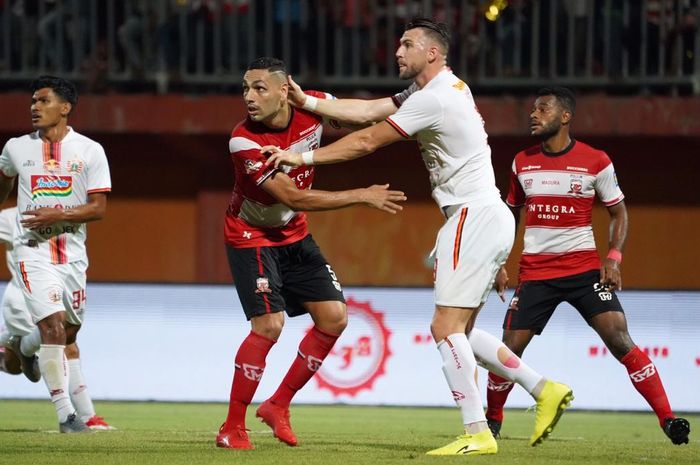 Striker Persija Jakarta, Marko Simic, mendapatkan pengawalan ketat dari bek Madura United, Jaimerson Xavier, pada laga pekan ke-14 Liga 1 2019.