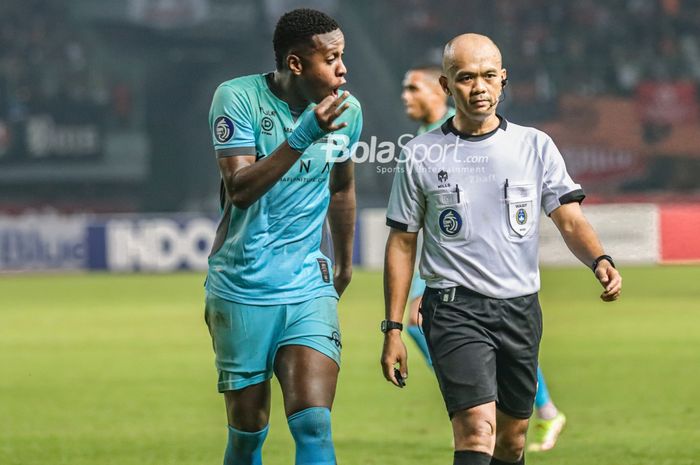 Pemain Madura United, Hugo Gomes Dos Santos Silva (kiri), sempat mengajukan protes kepada wasit bernama Ginanjar Rahman Latief (kanan) dalam laga pekan ke-10 Liga 1 2022 di Stadion Patriot Candrabhaga, Bekasi, Jawa Barat, 17 September 2022.
