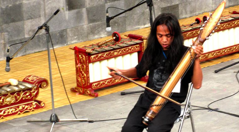 Wukir Suryadi memainkan instrumen musik buatannya, bambuwukir