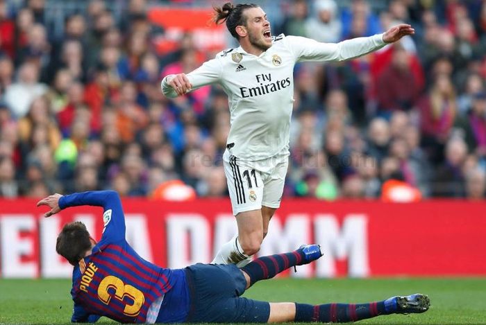 Penyerang Real Madrid, Gareth Bale, dihentikan oleh bek Barcelona, Gerard Pique, pada laga El Clasico di Liga Spanyol 2018-2019.