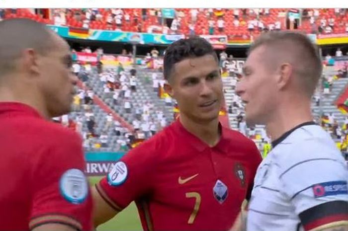 Dua pemain timnas Portugal, Pepe dan Cristiano Ronaldo, berbicara dengan gelandang timnas Jerman, Toni Kroos, seusai laga Grup F EURO 2020 di Stadion Football Arena, Sabtu (19/6/2021).
