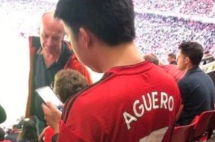 Seorang fan mengenakan jersey Manchester United dengan nama Aguero.