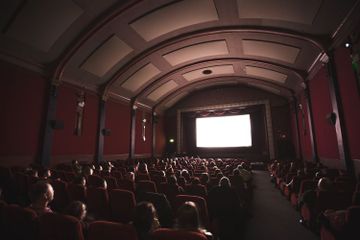 Dinding gedung bioskop dilapisi benda yang dapat menyerap bunyi untuk mengatasi gaung.