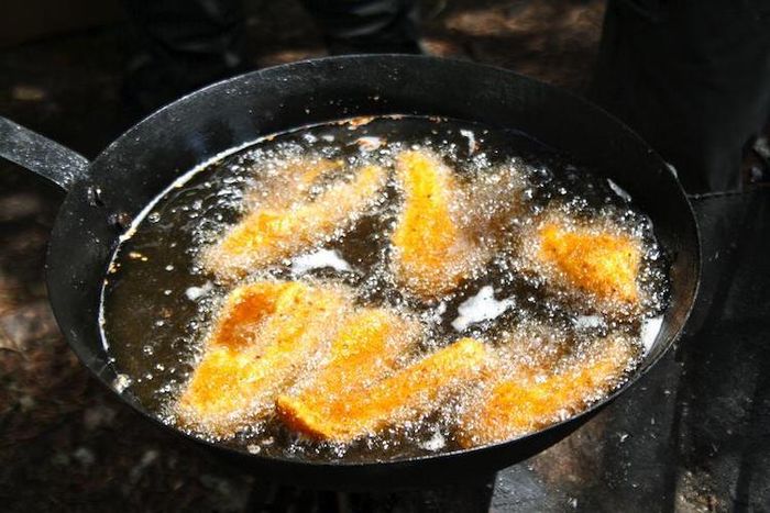 Menggoreng pisang di dalam minyak yang panas.