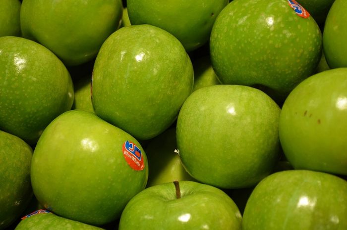 Pada buah apel terdapat stiker yang menempel pada buah.
