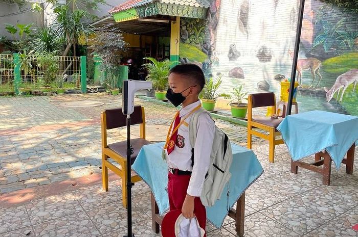 Pengecekan suhu tubuh dilakukan siswa SDN 01 Pondok-Pinang saat ingin pulang dari sekolah untuk mengurangi risiko penularan COVID-19.