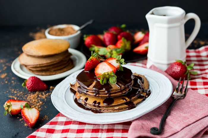Pancake saus cokelat adalah sajian yang nikmat disajikan sebagai camilan sore.