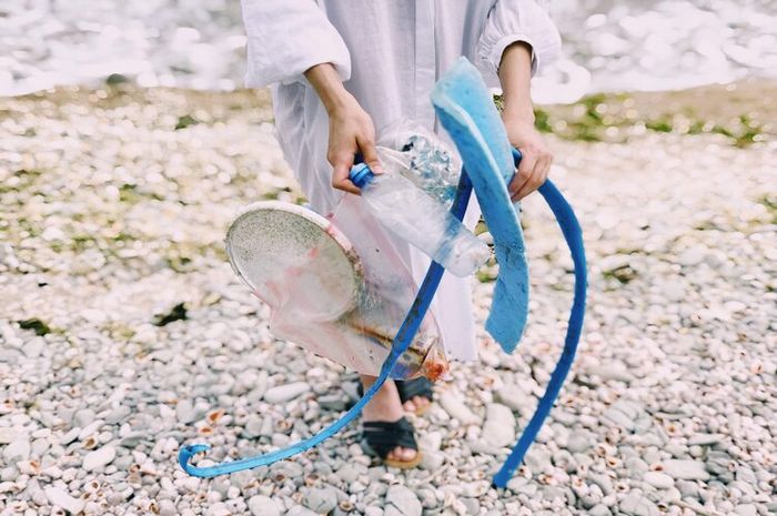 Membersihkan sampah di pantai merupakan salah satu contoh kepedulian terhadap lingkungan.