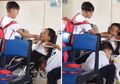 Viral Video Haru Dua Bocah Membantu Temannya yang Disabilitas, Satu Menyuapi dan Lainnya Mengipasi