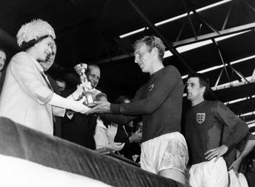 Ratu Elizabeth II menyerahkan trofi juara Piala Dunia 1966 kepada kapten timnas Inggris, Bobby Moore (30/7/1966).