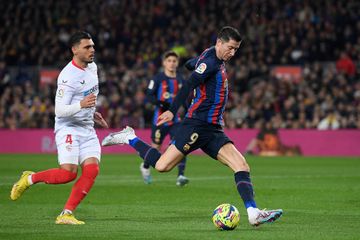 Robert Lewandowski (kanan) melepas tembakan dalam duel Barcelona vs Sevilla pada lanjutan Liga Spanyol di Spotify Camp Nou (5/2/2023).
