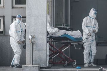Petugas medis membawa seorang pasien yang diduga terinfeksi virus misterius mirip SARS, ke rumah sakit Jinyintan, di Kota Wuhan, China, Sabtu (18/1/20)