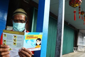 Warga membaca brosur mengenai virus corona saat sosialisasi dari PMI di Kota Tua Penagi, Natuna