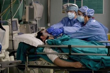  Anggota staf medis terlihat di samping pasien yang menderita Covid-19 di unit perawatan intensif di rumah sakit Circolo di Varese, Italia, 9 April 2020. 