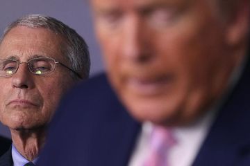 Epidemiolog Anthony Fauci berdiri di belakang Presiden Donald Trump