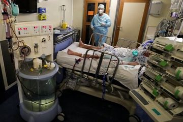 Tenaga medis sedang merawat seorang pasien Covid-19  di rumah sakit CHU de Liege, Belgia.  Studi menyebut setelah sembuh infeksi virus ini berdampak pada otak.