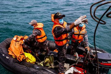 Prajurit TNI AL memindahkan kantong berisi temuan puing ke KRI Tenggiri-865 saat pencarian korban dan puing pesawat Sriwijaya Air nomor penerbangan SJ 182 di perairan Kepulauan Seribu, Jakarta, Selasa (12/1/2021). 