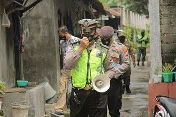 Polisi dan petugas keamanan inspeksi PPKM Mikro di suatu wilayah untuk  posko penanganan Covid-19.