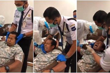 Seorang pria tampak takut disuntik pada program imunisasi massal  pemberian vaksin Covid-19.