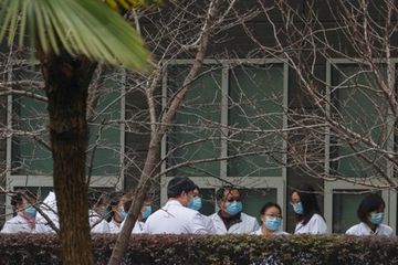 Ilmuwan dan pejabat China berjas lab menunggu di Pusat Pencegahan dan Pengendalian Penyakit Epidemi Hewan Hubei selama kunjungan tim Organisasi Kesehatan Dunia (WHO), yang bertugas menyelidiki asal mula penyakit virus korona (COVID-19), di Wuhan , Provinsi Hubei, Cina