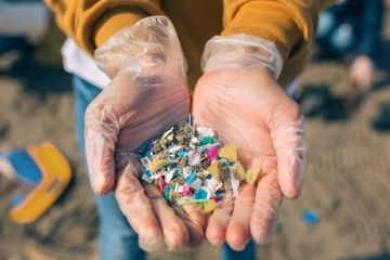 Seorang pemerhati lingkungan menunjukkan segenggam plastik, Istanbul, Turki, 6 April 2022.