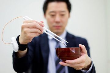 Seorang karyawan Kirin Holdings mendemonstrasikan sumpit yang memberi rasa asin di Tokyo, Jepang, 15 April 2022. 