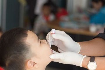 Seorang anak menerima imunisasi polio saat Bulan Imunisasi Anak Nasional.