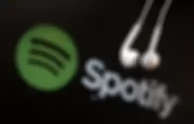 Headphones are seen in front of a logo of online music streaming service Spotify in this illustratio