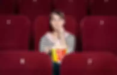 Menonton film di bioskop sendirian.