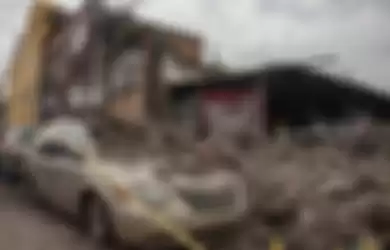 Sebuah gedung hancur dan reruntuhannya menimpa mobil saat gempa di Mexico 