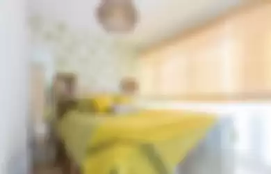 Warna seprai kuning di kamar tidur. Kuning lebih lembut dan lebih pastel kondusif untuk tidur. 