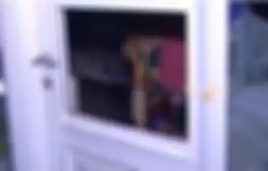 Angel Lelga terlihat melalui lubang di pintu kamarnya yang jebol