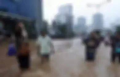 Para karyawan menmebus banjir yang menggenangi Jalan MH Thamrin, Jakarta, Kamis (17/1/2013). Akibatnyta lalu luntas di kawasan jantung ibu kota tersebut lumpuh total. Para karyawan menembus banjir