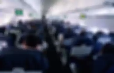 Passengers sitting in commercial airliner, rear view