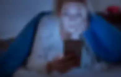 Ilustrasi bermain ponsel di ruangan gelap