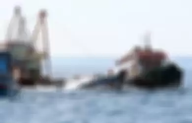 Sejumlah anak buah kapal bantu menyemprotkan air menggunakan mesin pompa ke dalam kapal nelayan Vietnam saat penenggelaman di Pulau Datuk, Kabupaten Mempawah, Kalimantan Barat, Sabtu (4/5/2019). Kementerian Kelautan dan Perikanan menenggelamkan 13 dari 51 kapal nelayan asing asal Vietnam.