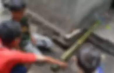 Tiga orang anak sekolah dasar di Kompleks Mabako, Kelurahan Watunggene, Kecamatan Kota Komba, Manggarai Timur, Flores, NTT, Jumat (19/12/2014) membunyikan meriam bambu di samping rumah mereka. Tradisi meriam bambu merupakan warisan leluhur orang Flores untuk menyambut kelahiran Isa Almasih.