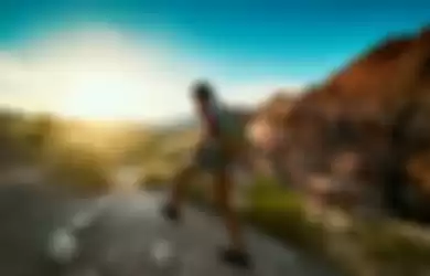 woman hiking at Red Rock Canyon during sunset with backpack shot with lens flare