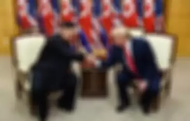 Pemimpin Korea Utara Kim Jong Un (kiri) dan Presiden AS Donald Trump berjabat tangan dalam sebuah pertemuan di wilayah keamanan bersama (JSA) Panmunjom di zona demiliterisasi (DMZ) Korea, Minggu (30/6/2019). Kedatangan Trump ke zona demiliterisasi Korea awalnya diagendakan untuk pertemuan dengan Pre