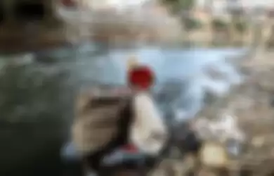 Warga beraktivitas di pemukiman padat penduduk di bantaran Sungai Ciliwung, Manggarai, Jakarta, Minggu (28/7/2019). 