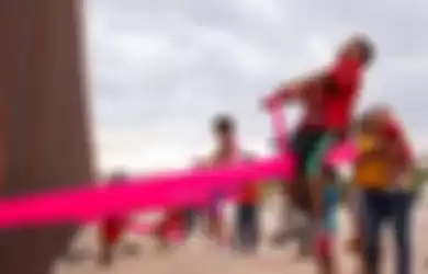 Anak-anak bermain jungkat-jungkit di perbatasan Meksiko-AS.