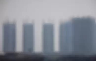 Pemandangan laut dengan latar belakang gedung bertingkat yang diselimuti asap polusi di Jakarta Utara, Rabu (31/7/2019). Berdasarkan data situs penyedia peta polusi daring harian kota-kota besar di dunia AirVisual, menempatkan Jakarta pada urutan pertama kota terpolusi sedunia pada Senin (29/7) pagi