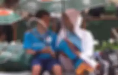 Novak Djokovic ajak seorang ballboy bersantai di tengah laga yang dihentikan karena hujan.