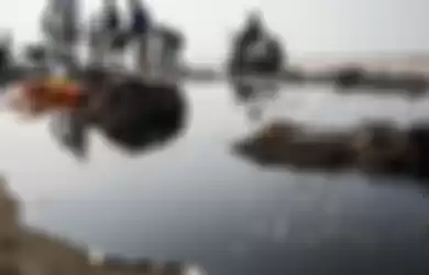 Warga mengumpulkan limbah tumpahan minyak Oil Spill yang tercecer milik Pertamina di Pesisir Pantai Cemarajaya, Karawang, Jawa Barat, Minggu (4/8/2019). Pasir yang tercemar minyak tersebut dikumpulkan dan akan dipindahkan ke pabrik penyimpanan limbah B3 (Bahan Berbahaya dan Beracun) untuk dimusnahkan.