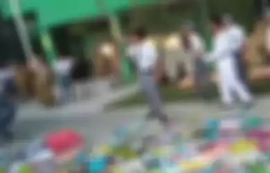 Siswa melempar buku ke tengah tumpukan buku-buku dalam aksi unjuk rasa di halaman MAN Bangkalan, Madura, Senin (5/8)