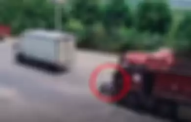 Video saat pengendara skuter putih ini tidak memperhatikan kondisi jalan dan melaju di posisi titik buta pengemudi truk.