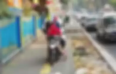 Seorang pengendara motor yang tidak merasa bersalah, berusaha menyemprot seorang pejalan kaki yang menegurnya dikarenakan menerobos trotoar .