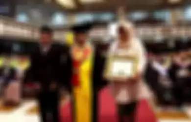 Kedua orang tua Irza Laila Nur Trisna maju ke depan auditorium UNS untuk menerima ijazah anaknya dari rektor.